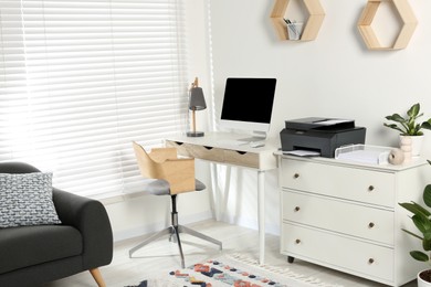 Stylish workplace with modern computer, printer and lamp