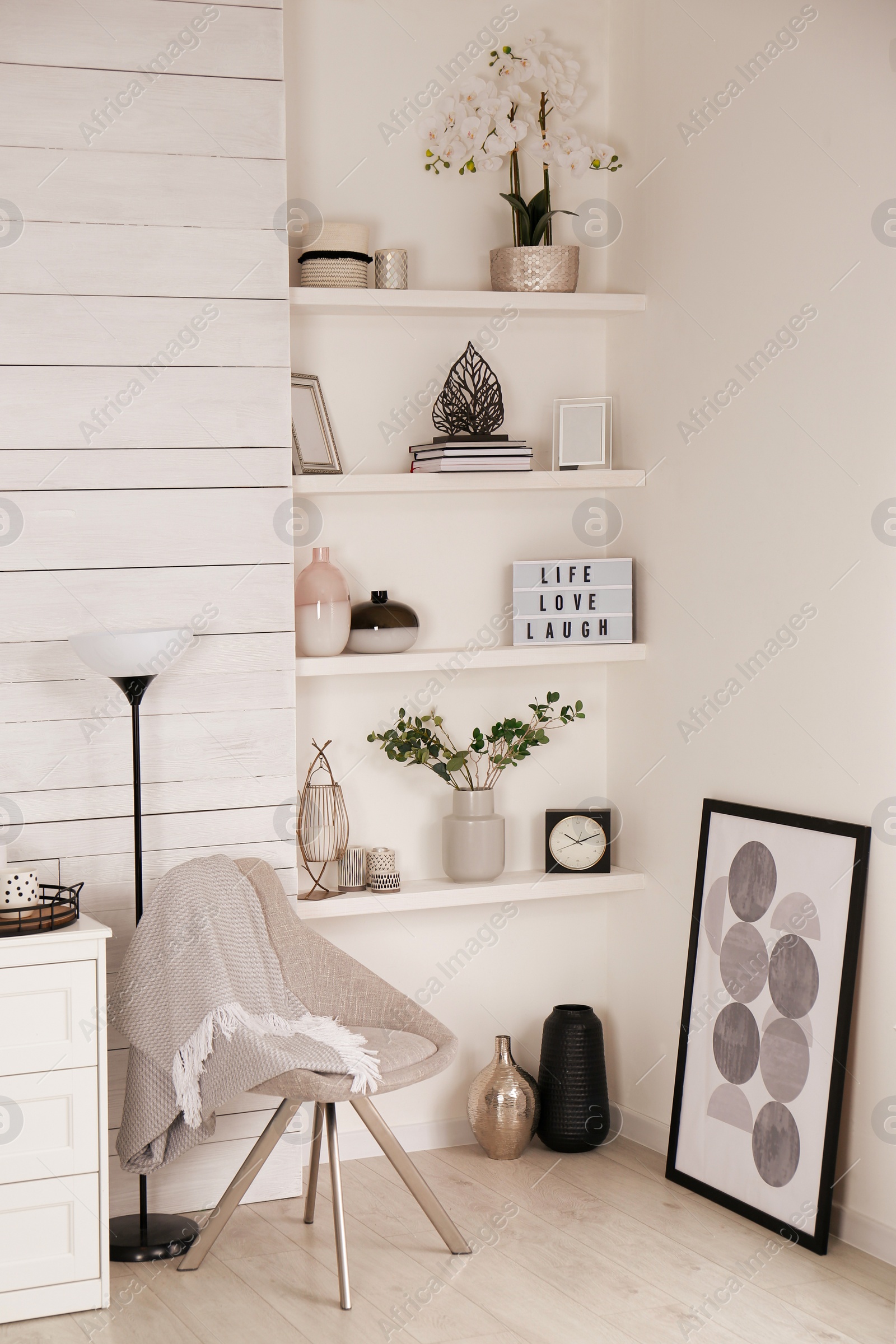 Photo of Cozy room interior with stylish furniture, wall shelves and beautiful decor elements