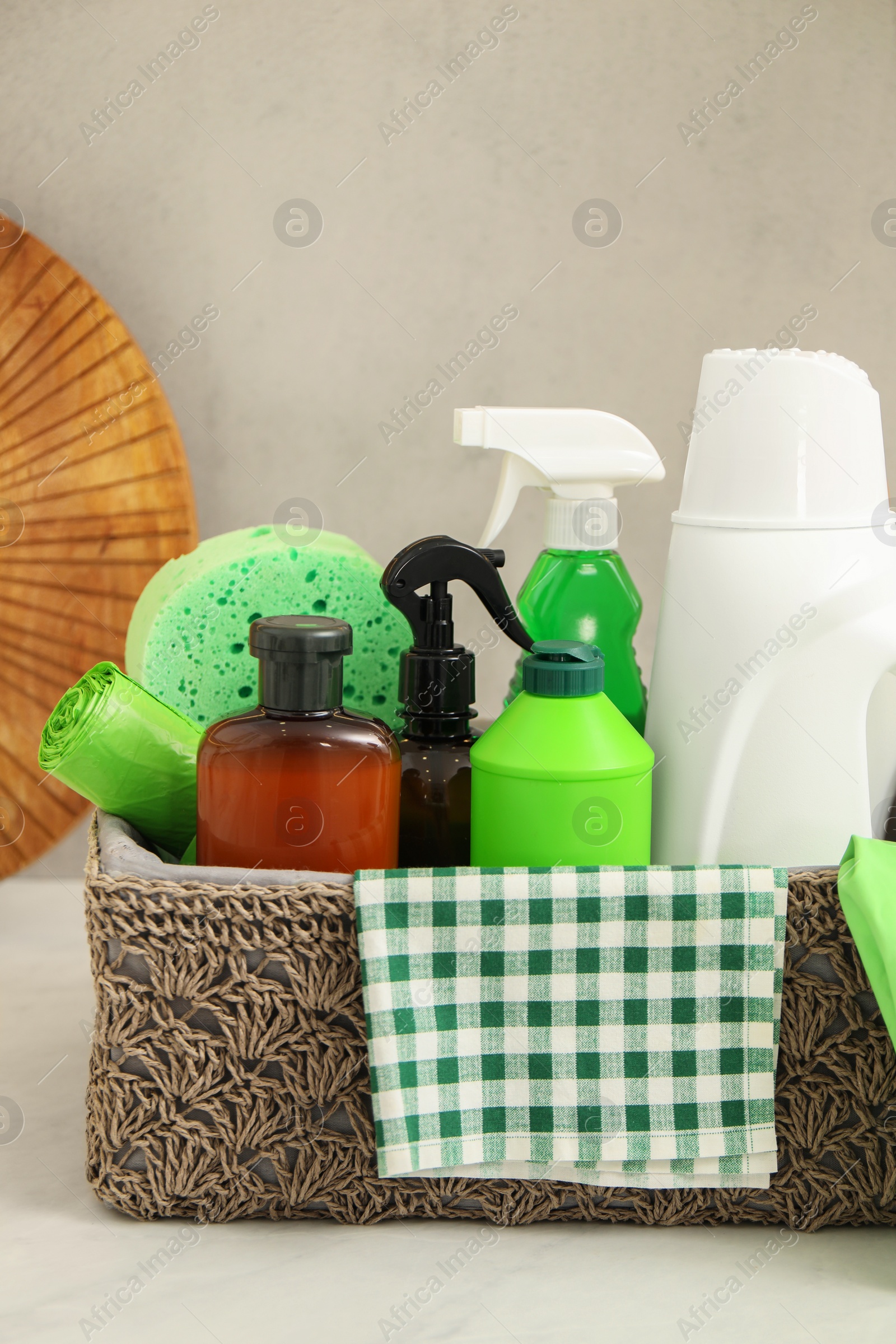 Photo of Different cleaning supplies in basket on countertop