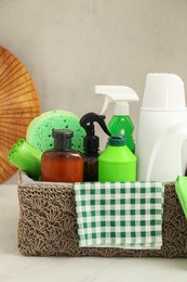 Different cleaning supplies in basket on countertop