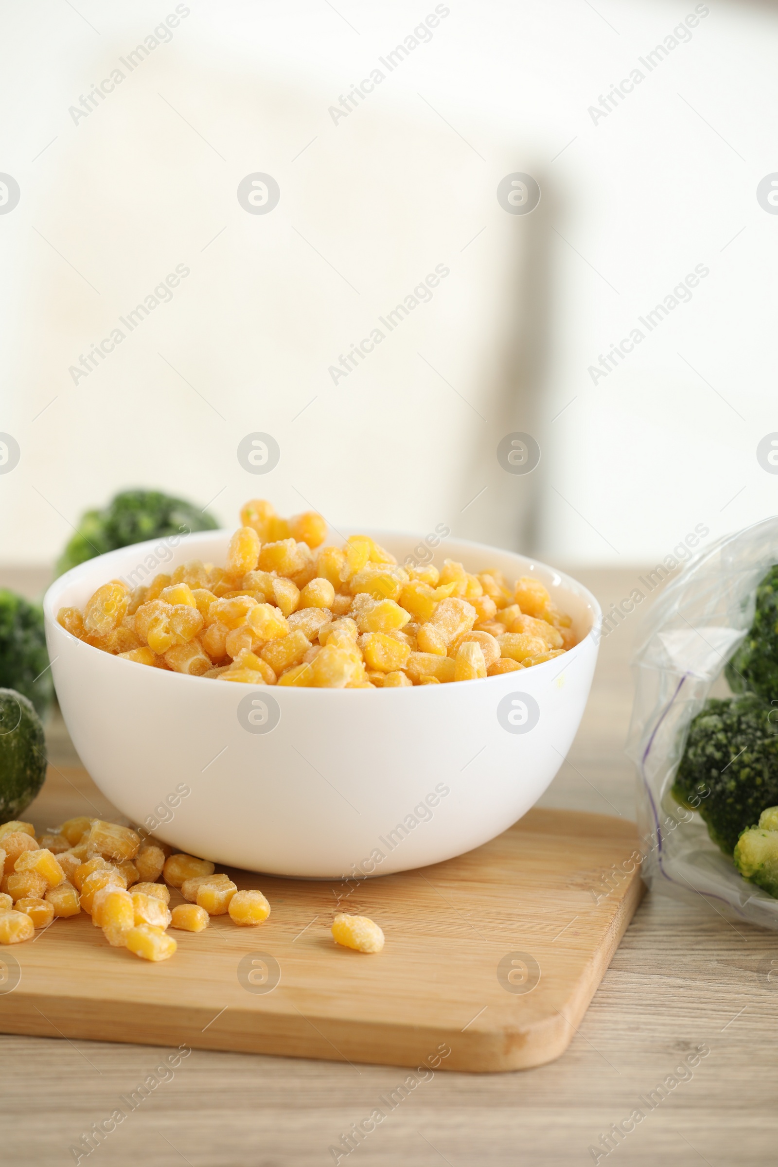 Photo of Frozen vegetables on wooden table indoors, closeup. Space for text