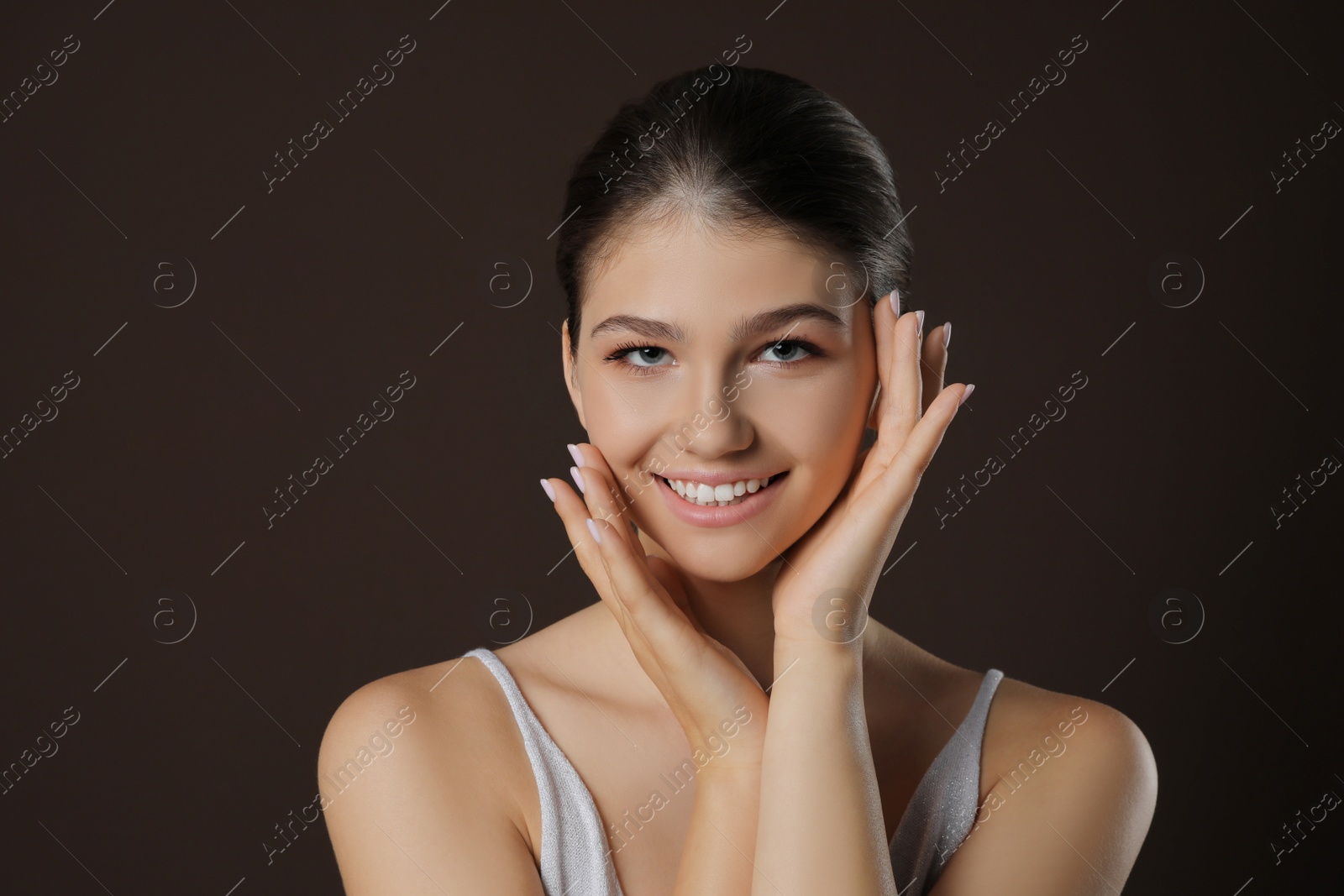 Photo of Portrait of pretty girl on brown background. Beautiful face with perfect smooth skin