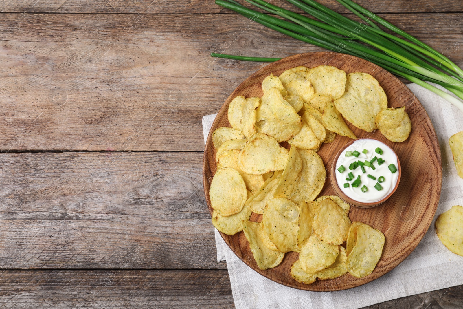 Photo of Chips with sour cream on wooden background, flat lay. Space for text