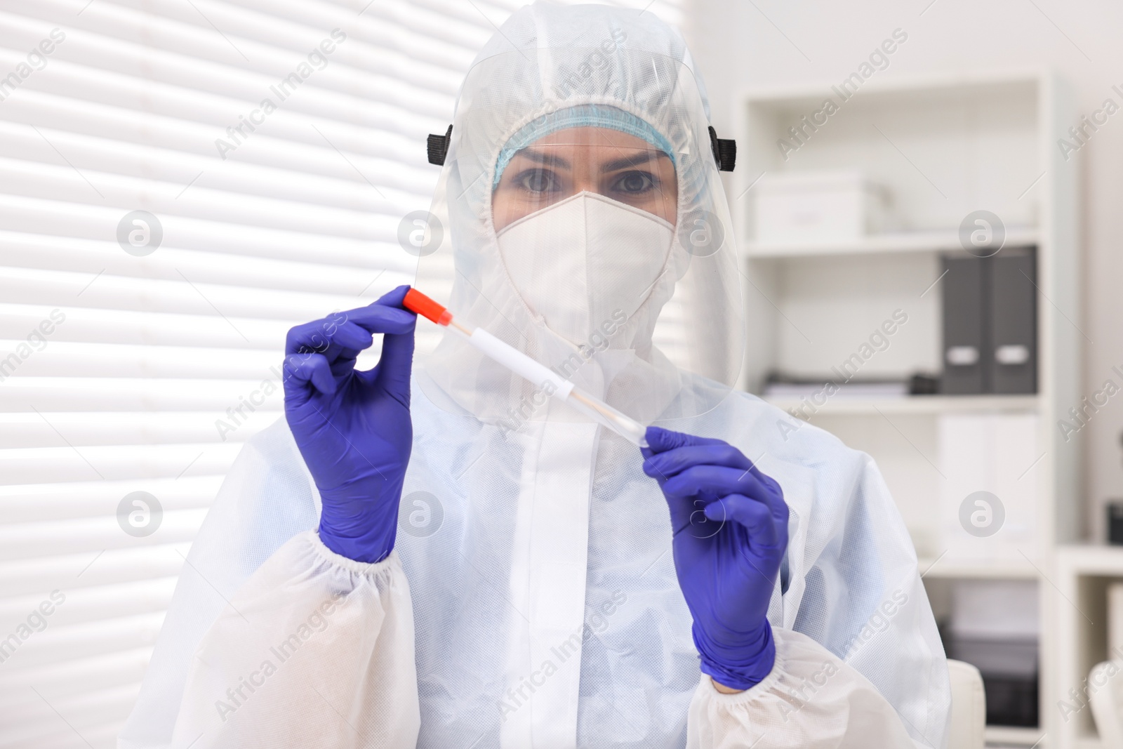 Photo of Laboratory testing. Doctor in uniform with cotton swab and tube at hospital