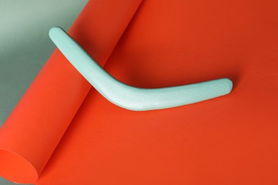 Creative composition with turquoise wooden boomerang on color background