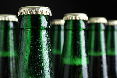 Bottles of beer on dark background, closeup. Space for text