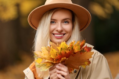 Photo of Portrait of happy woman with autumn leaves outdoors