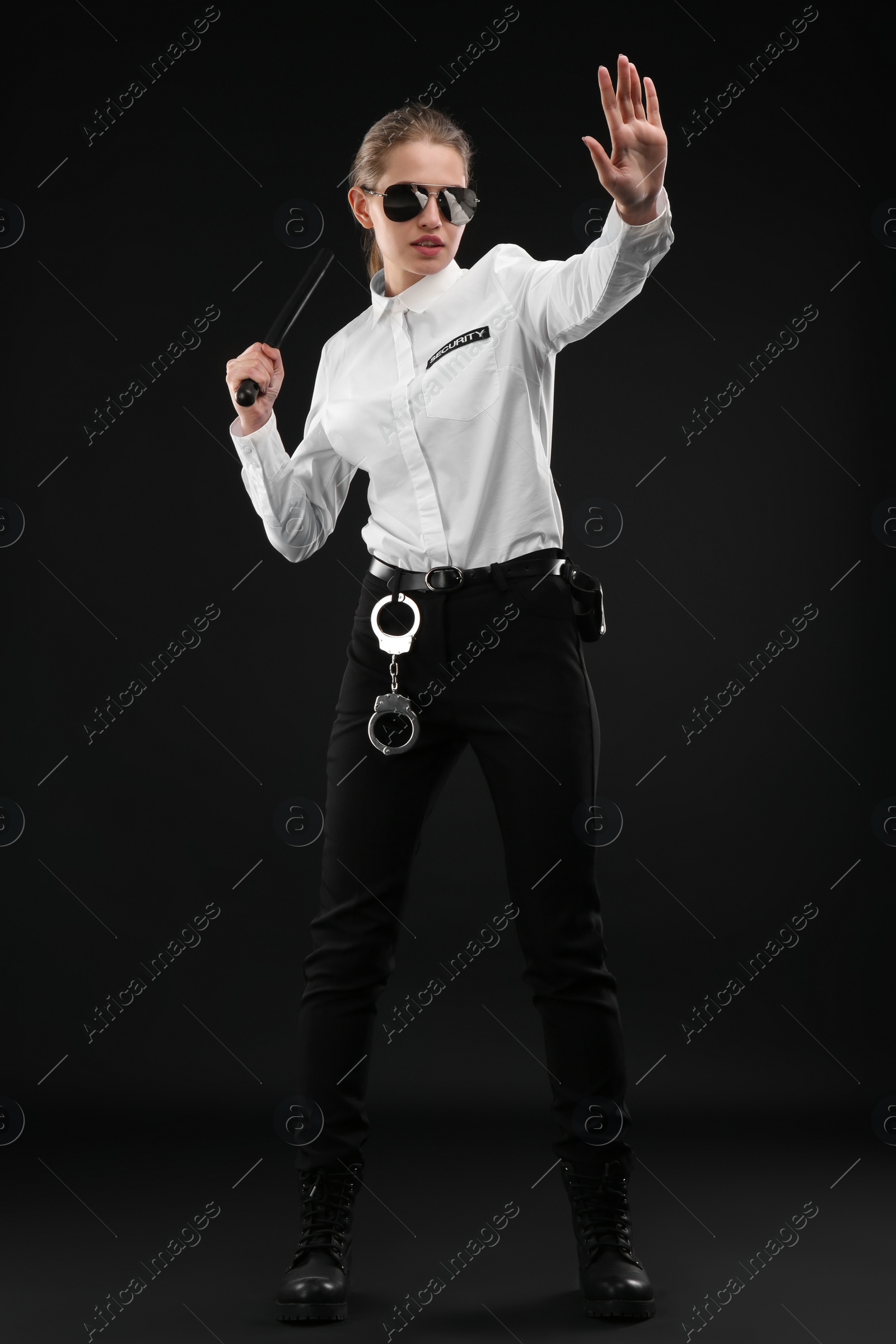 Photo of Female security guard with police baton on dark background