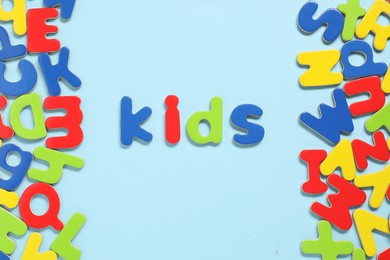 Photo of Word Kids made of magnetic letters on light blue background, flat lay. Learning alphabet