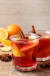 Photo of Aromatic punch drink and ingredients on wooden table