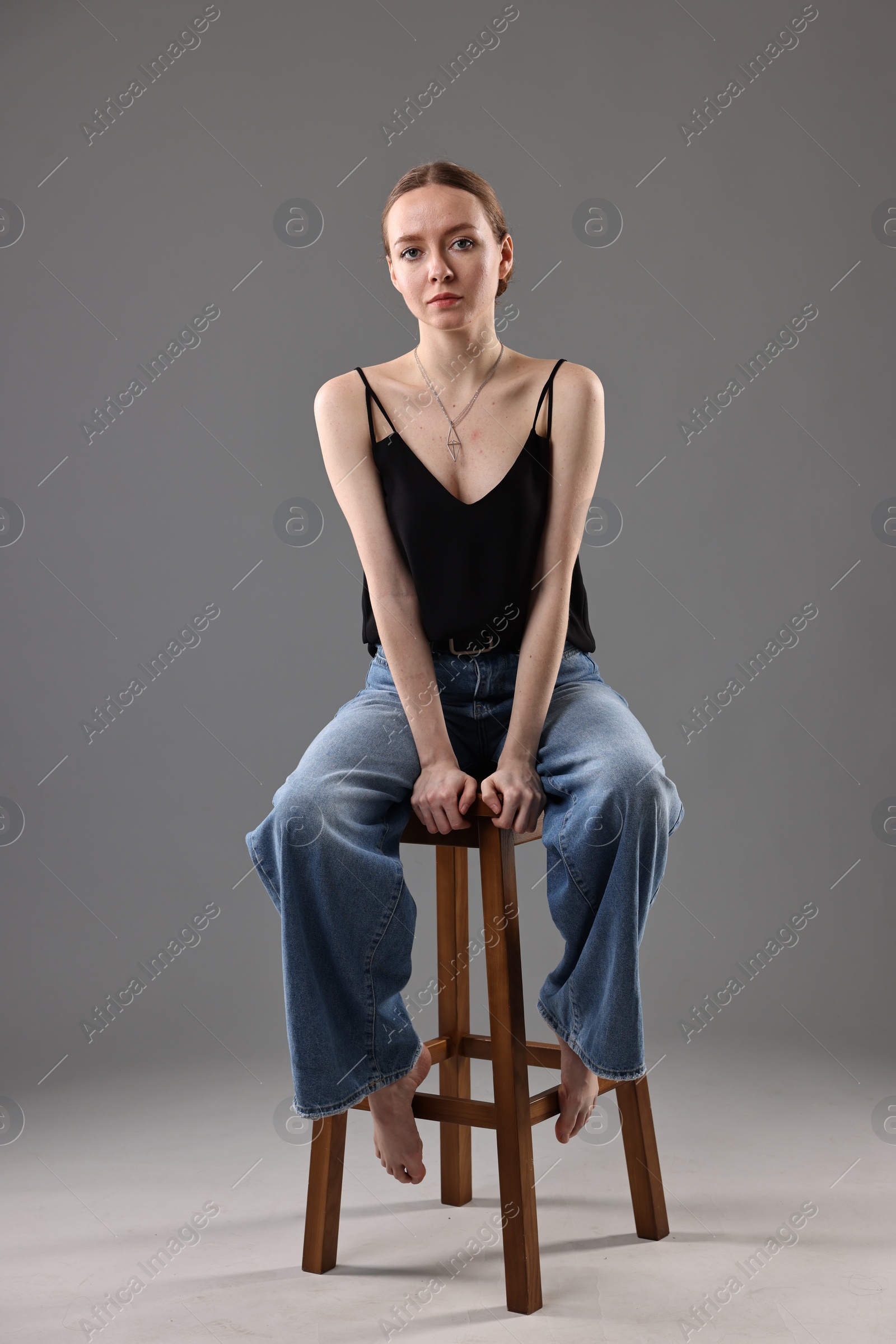 Photo of Fashionable portrait of beautiful young woman on grey background