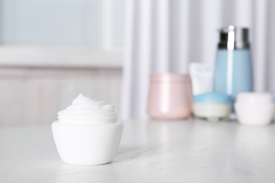 Jar of body care product on table against blurred background. Space for text