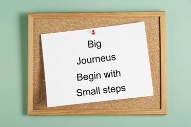 Photo of Corkboard and phrase Big Journeys Begin With Small Steps on light green background, top view. Motivational quote