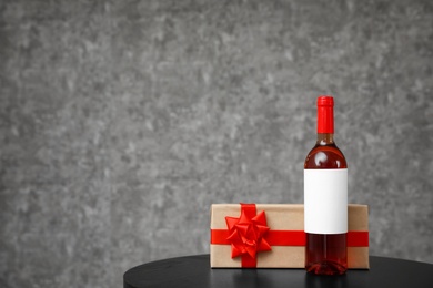 Gift box and bottle of wine on table. Space for design