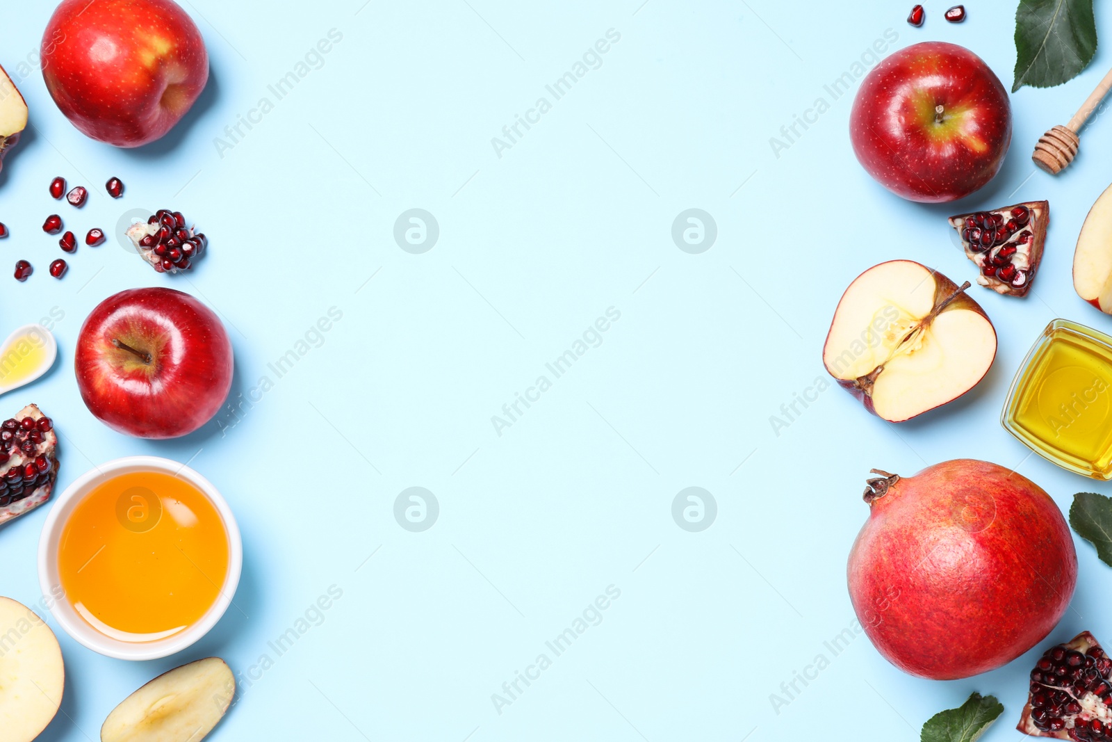 Photo of Honey, apples and pomegranates on light blue background, flat lay with space for text. Rosh Hashanah holiday