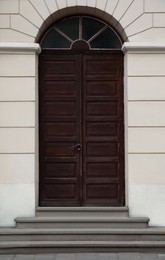 View of house with beautiful arched wooden door. Exterior design