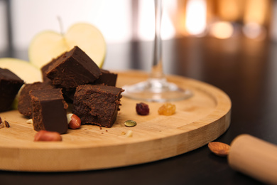 Delicious brunost cheese and nuts on table, closeup