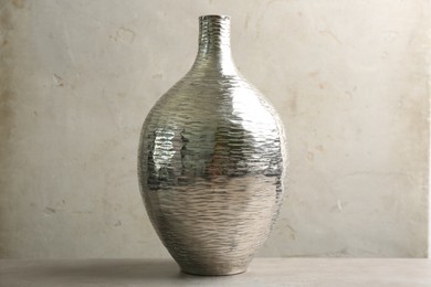 Stylish silver ceramic vase on grey table