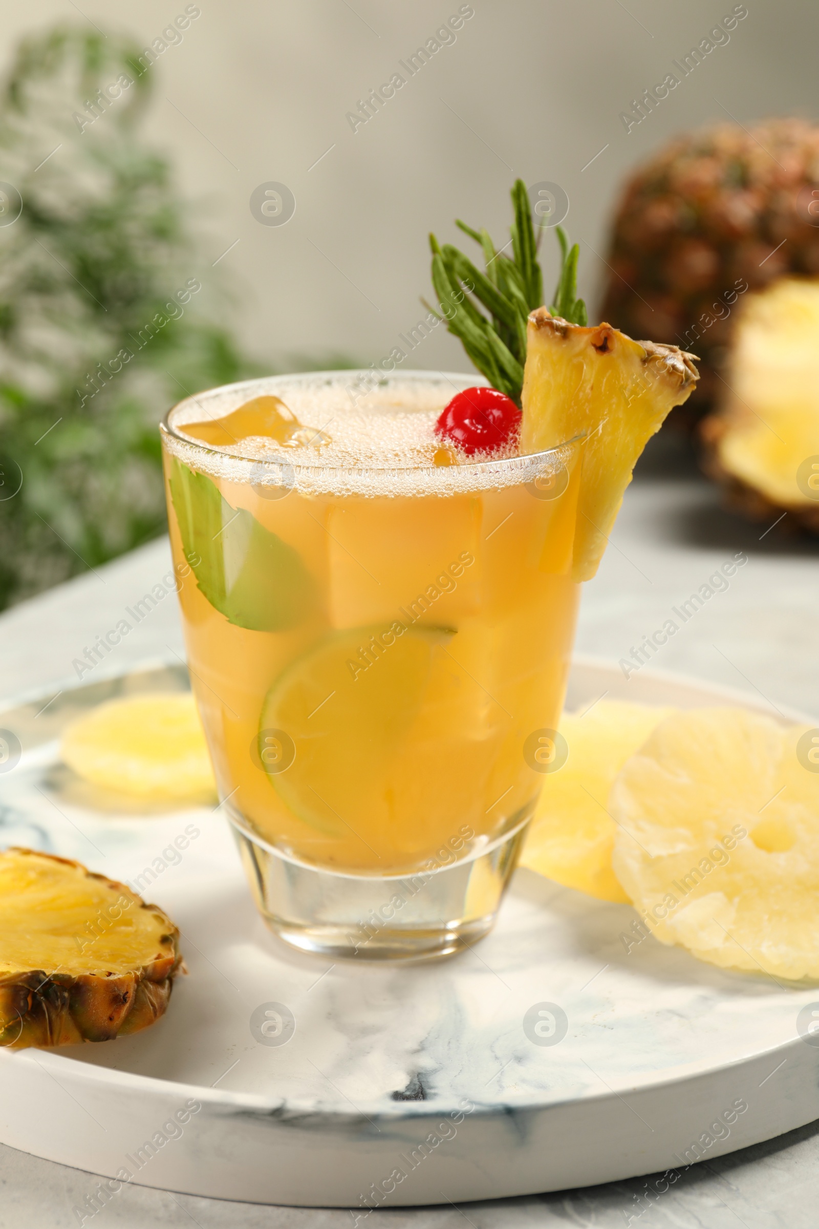 Photo of Glass of tasty pineapple cocktail and fresh fruit on light gray table