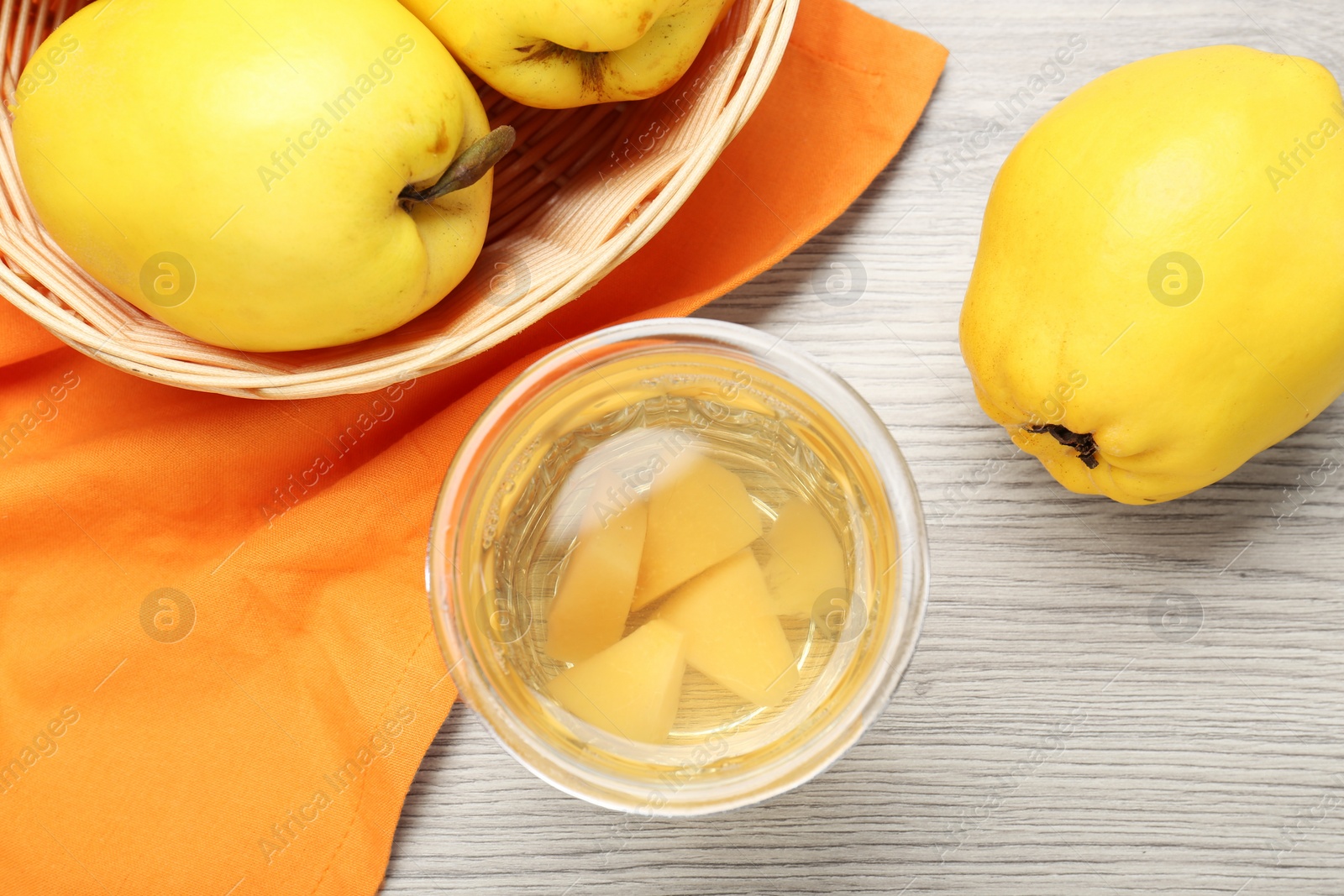 Photo of Delicious quince drink in glass and fresh fruits on wooden table, top view