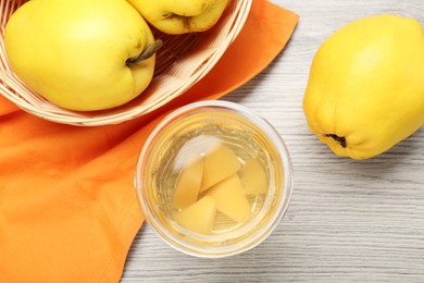 Photo of Delicious quince drink in glass and fresh fruits on wooden table, top view