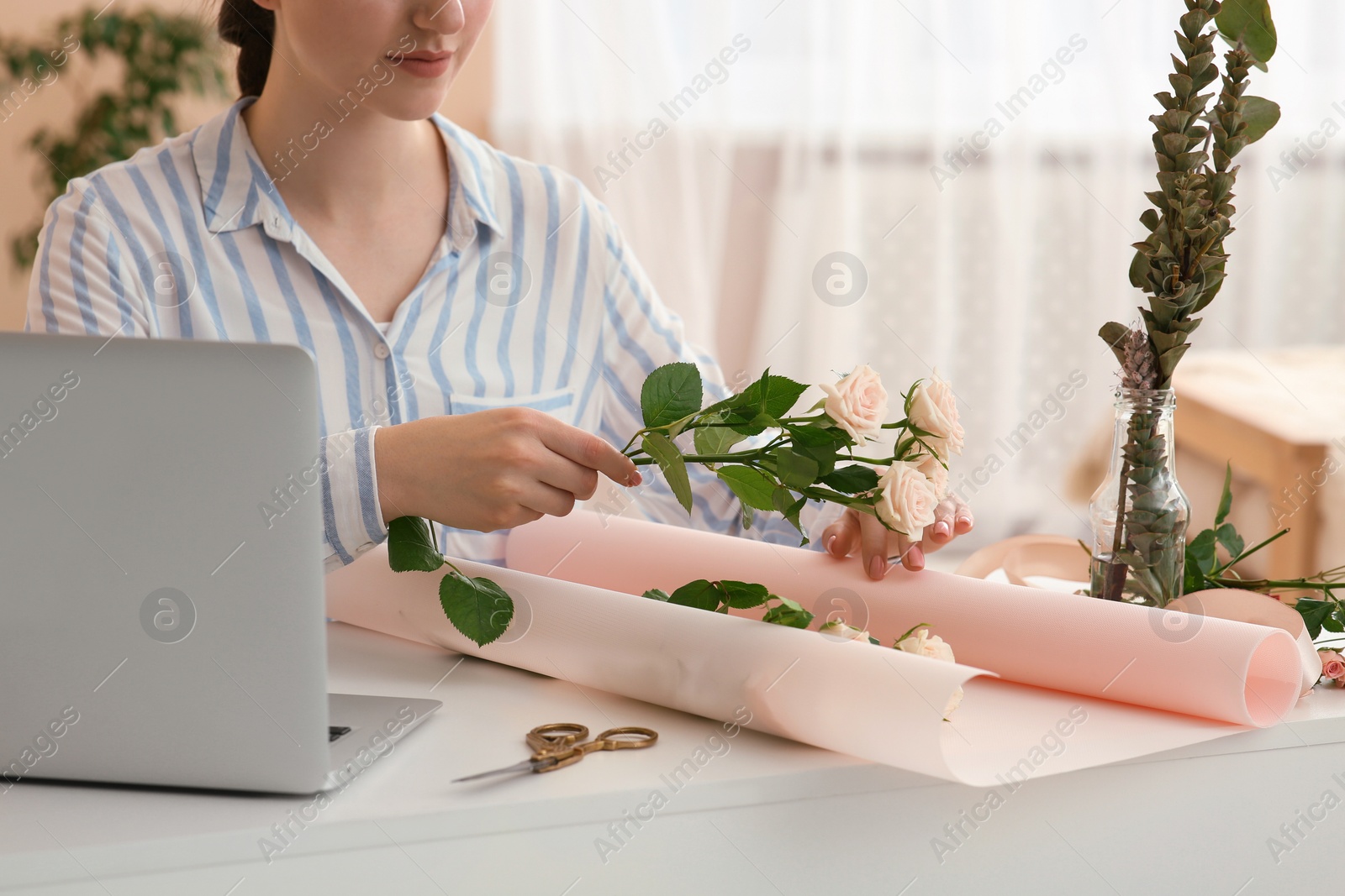 Photo of Woman making bouquet following online florist course at home, closeup. Time for hobby