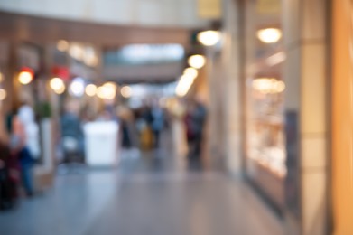 Blurred view of shopping mall with different stores, bokeh effect