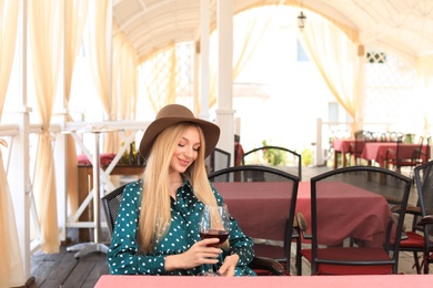 Beautiful woman with glass of wine in restaurant