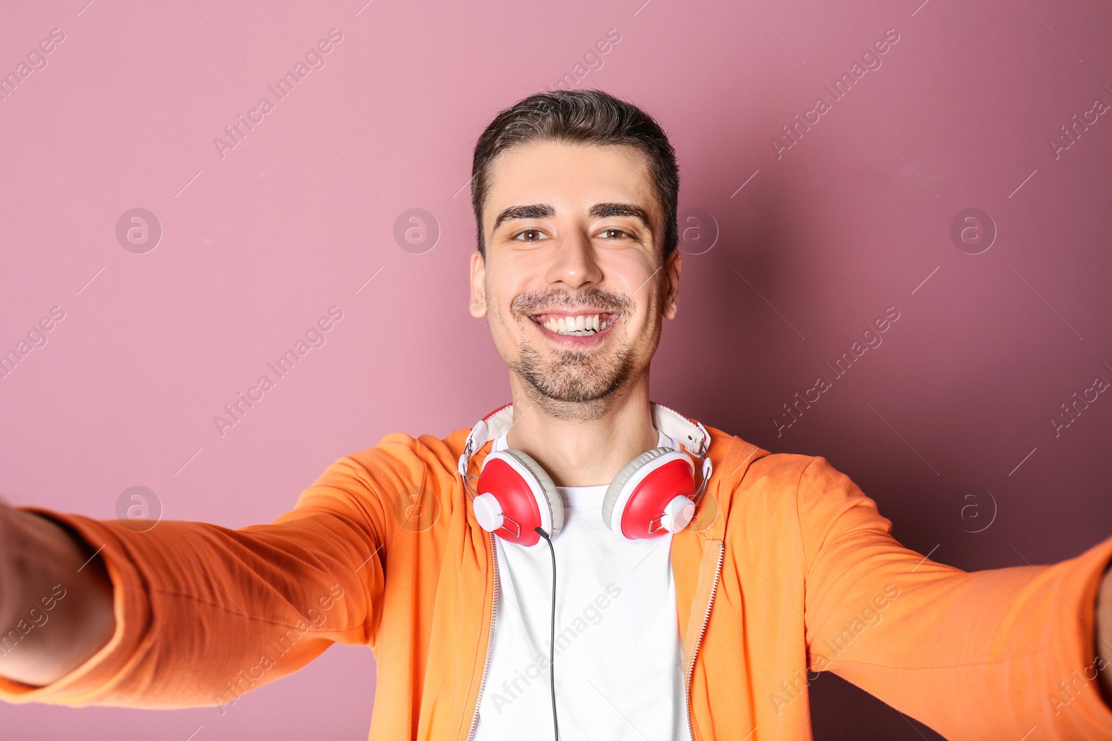 Photo of Handsome man taking selfie against color background