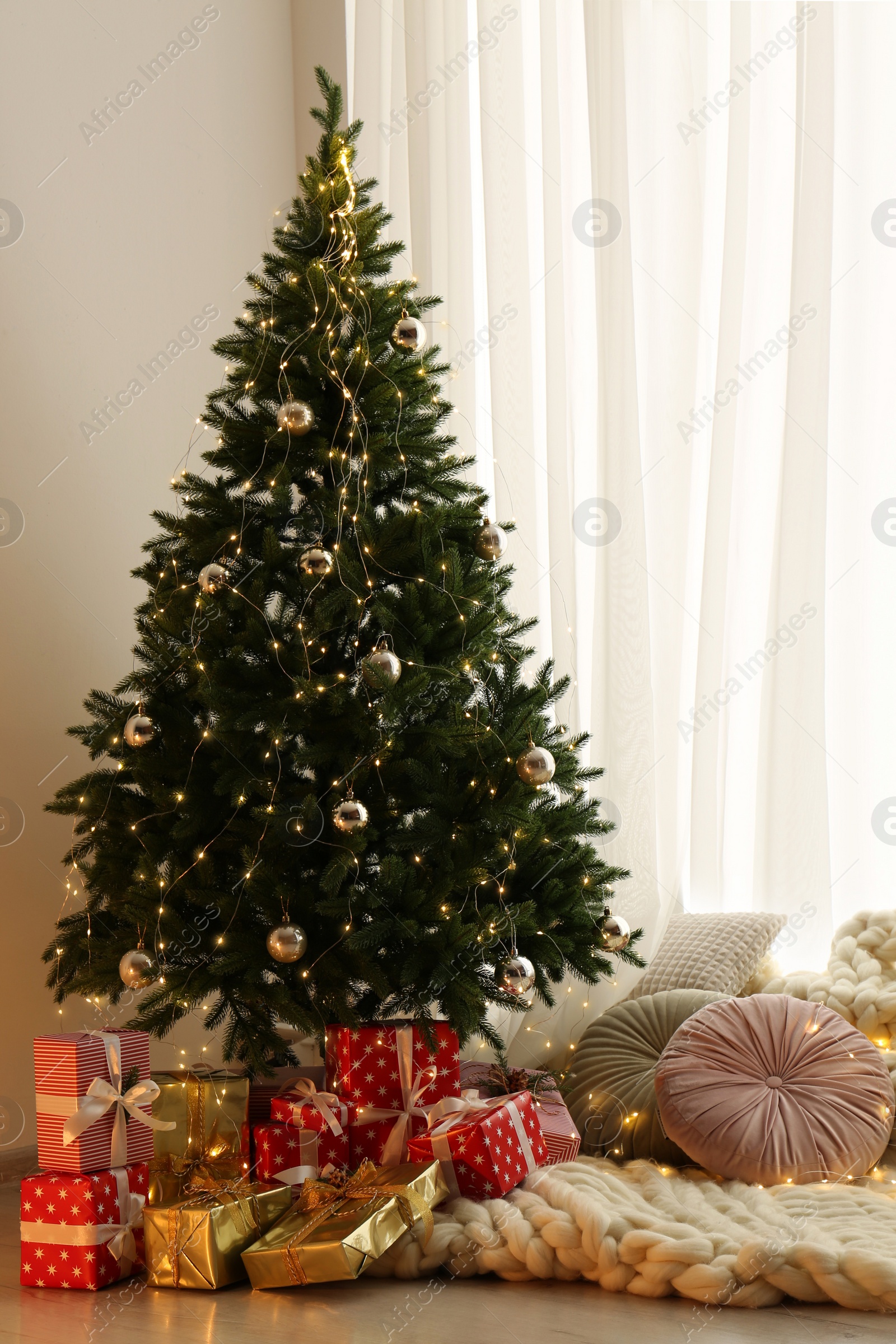 Photo of Beautiful Christmas tree and gift boxes in light room. Interior design