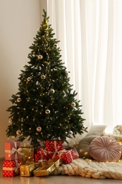 Photo of Beautiful Christmas tree and gift boxes in light room. Interior design