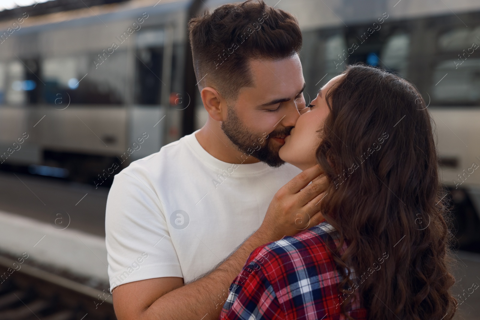 Photo of Long-distance relationship. Beautiful couple kissing on platform of railway station