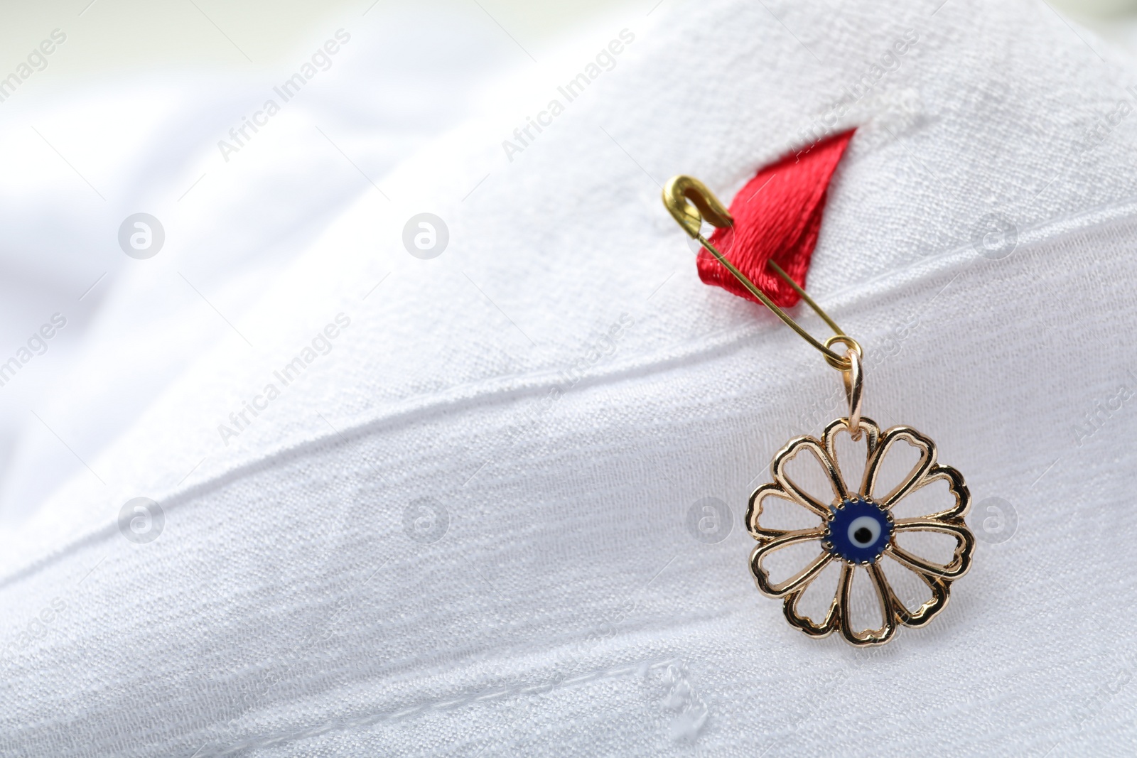 Photo of Evil eye safety pin on clothing, closeup