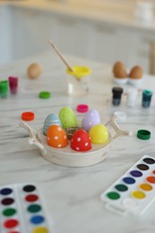 Happy Easter. Painted eggs and watercolor on white marble table indoors