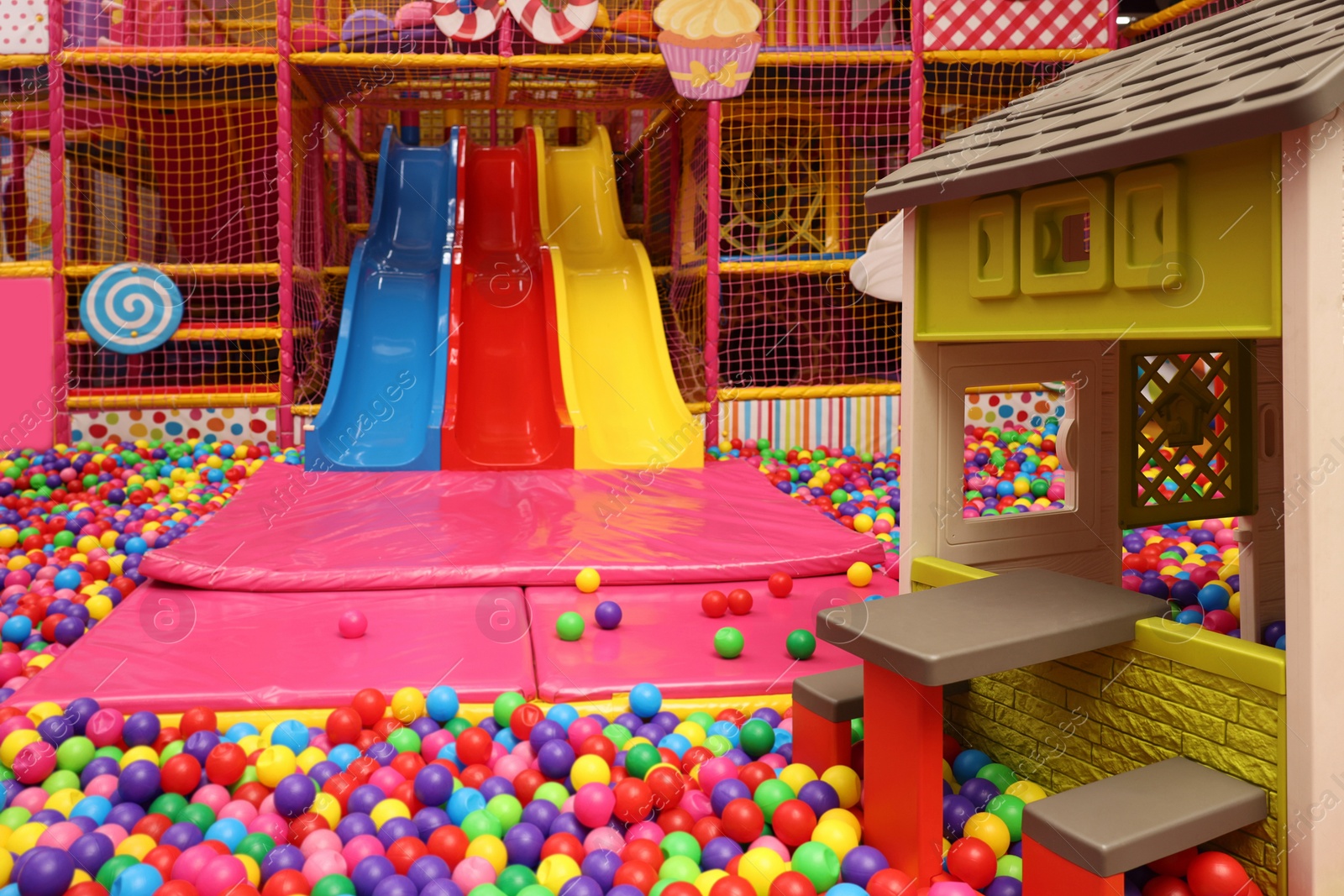 Photo of Slides, playhouse and many colorful balls in ball pit