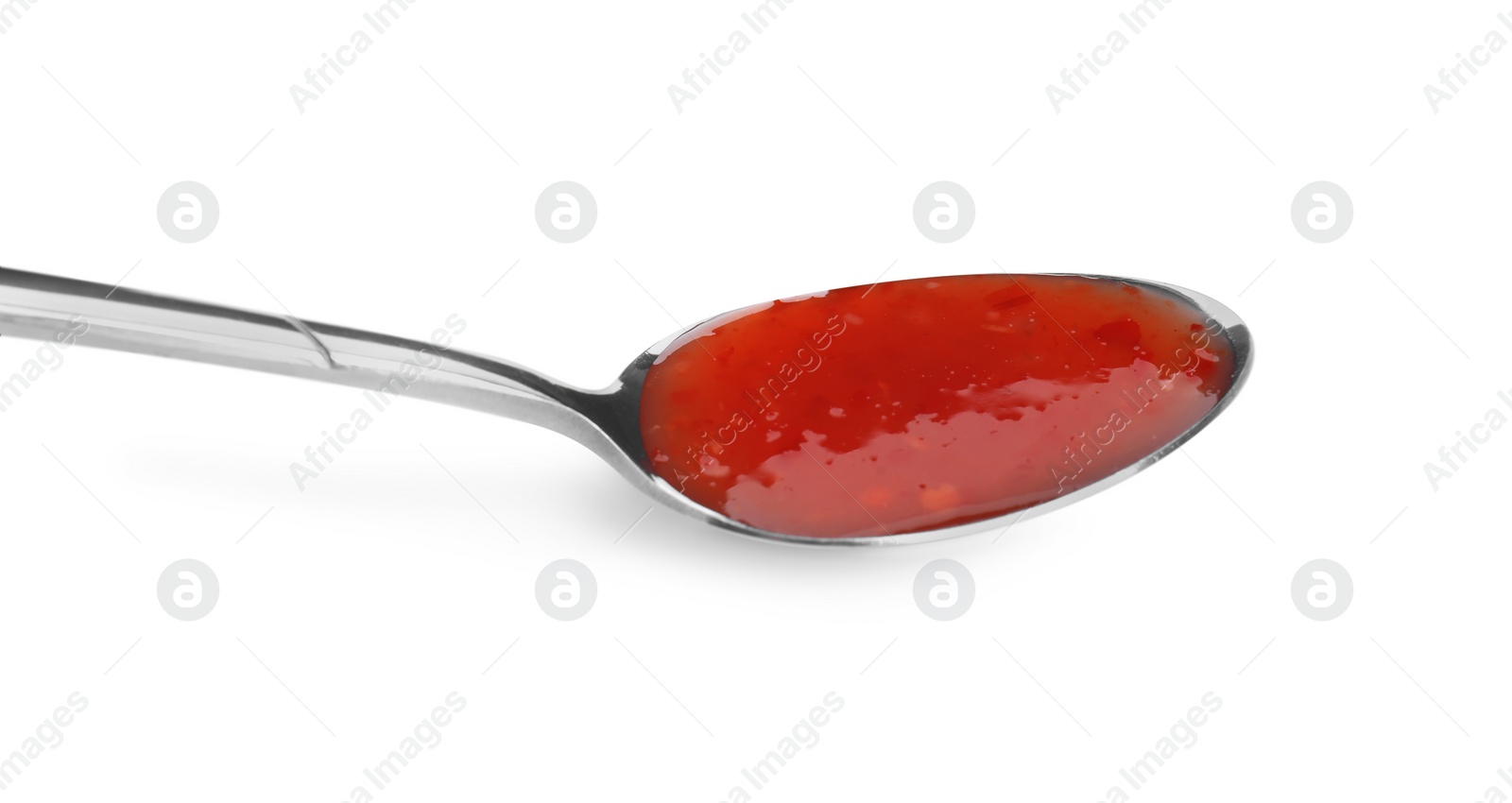 Photo of Spicy chili sauce in spoon isolated on white