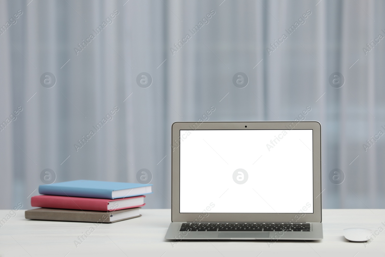 Photo of Laptop with blank screen on table indoors. Space for text