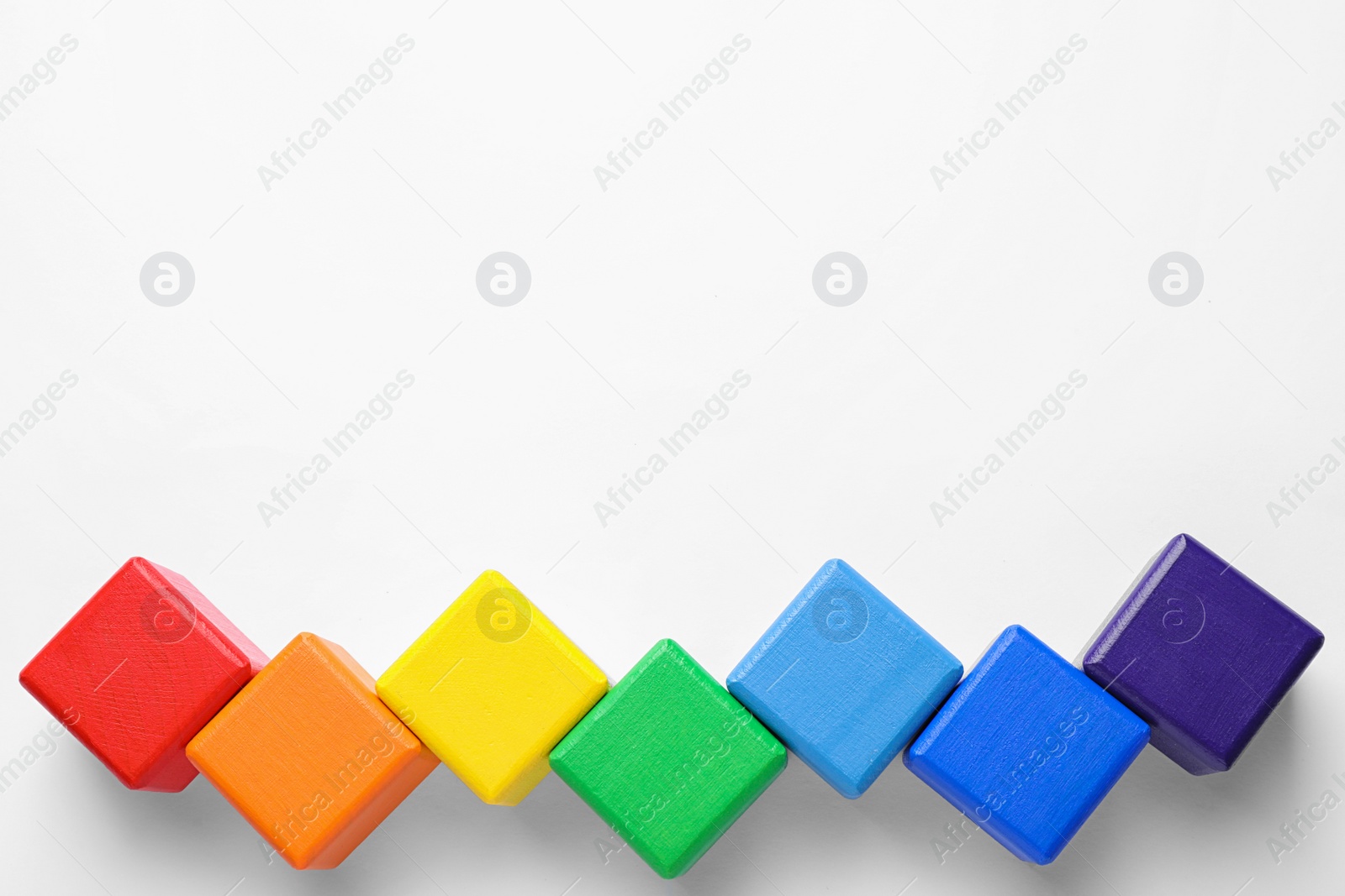 Photo of Bright wooden cubes on white background, top view. Rainbow colors