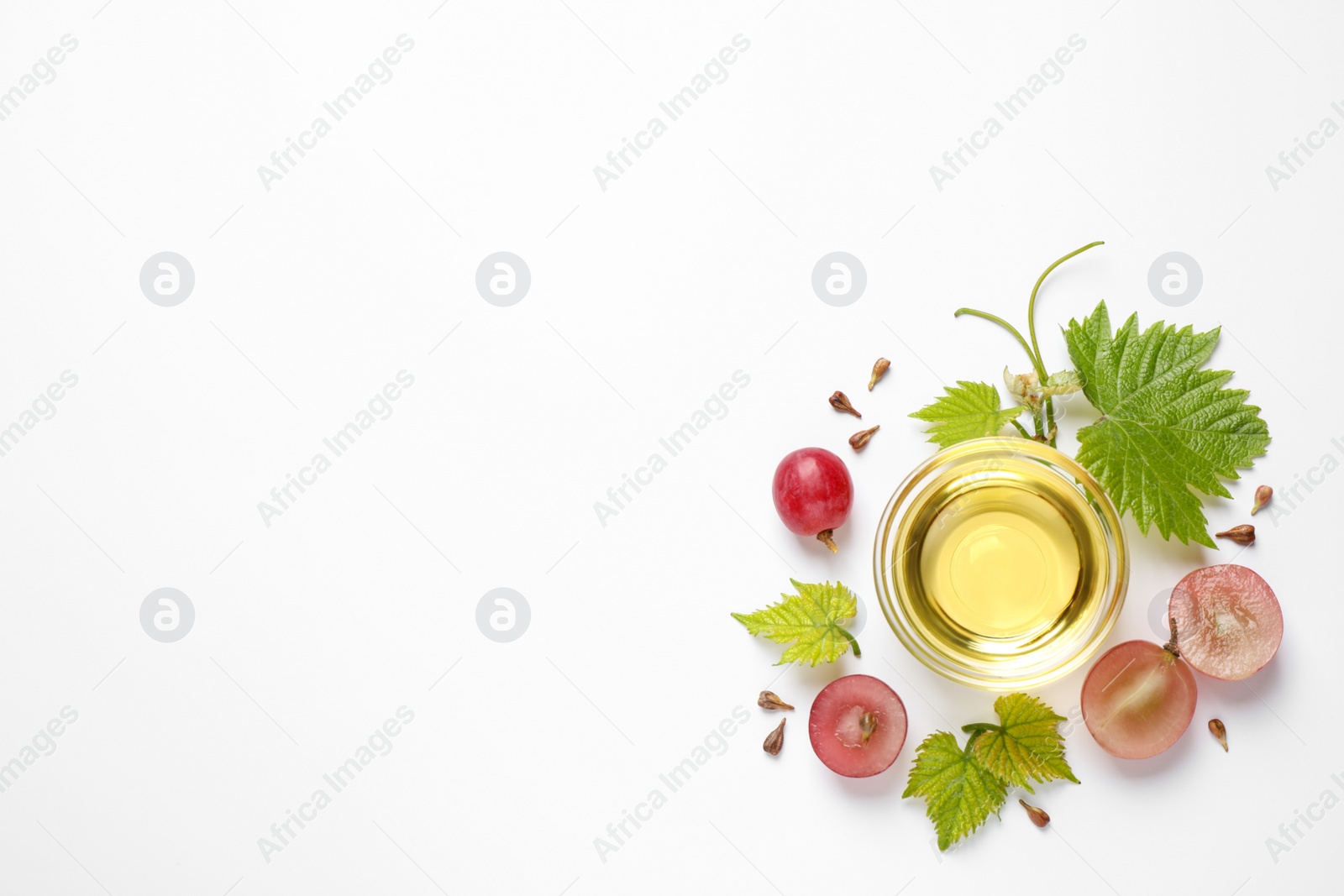 Photo of Composition with bowl of natural grape seed oil on white background, top view. Organic cosmetic