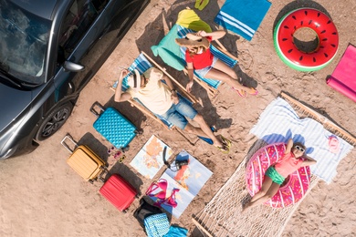 Image of Family with beach accessories on sandy beach, aerial view. Summer trip