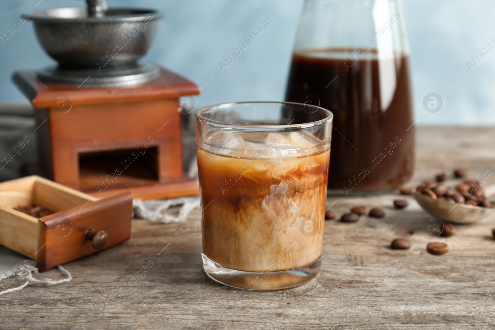 Photo of Glass with cold brew coffee and milk on wooden table