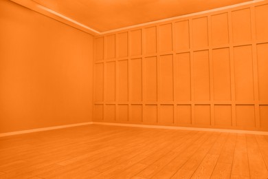 Empty spacious room with orange wooden floor and walls