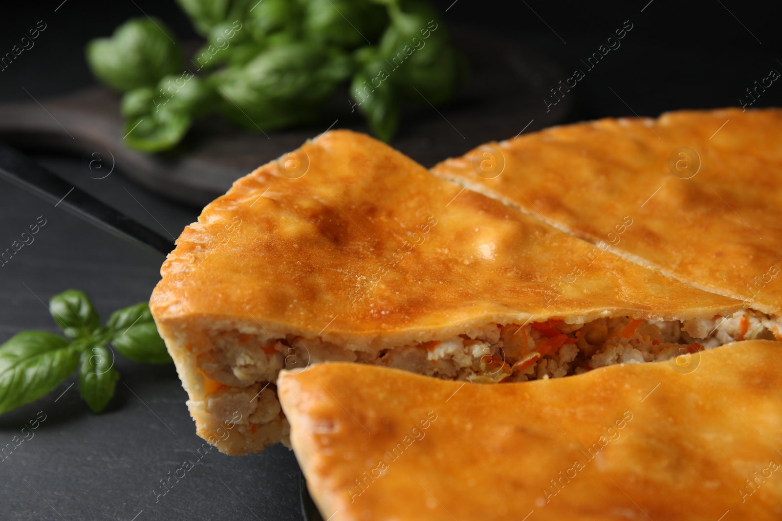 Photo of Delicious pie with meat on black table, closeup