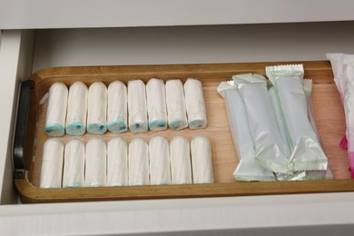 Photo of Storage of many different tampons in white drawer. Menstrual hygienic product