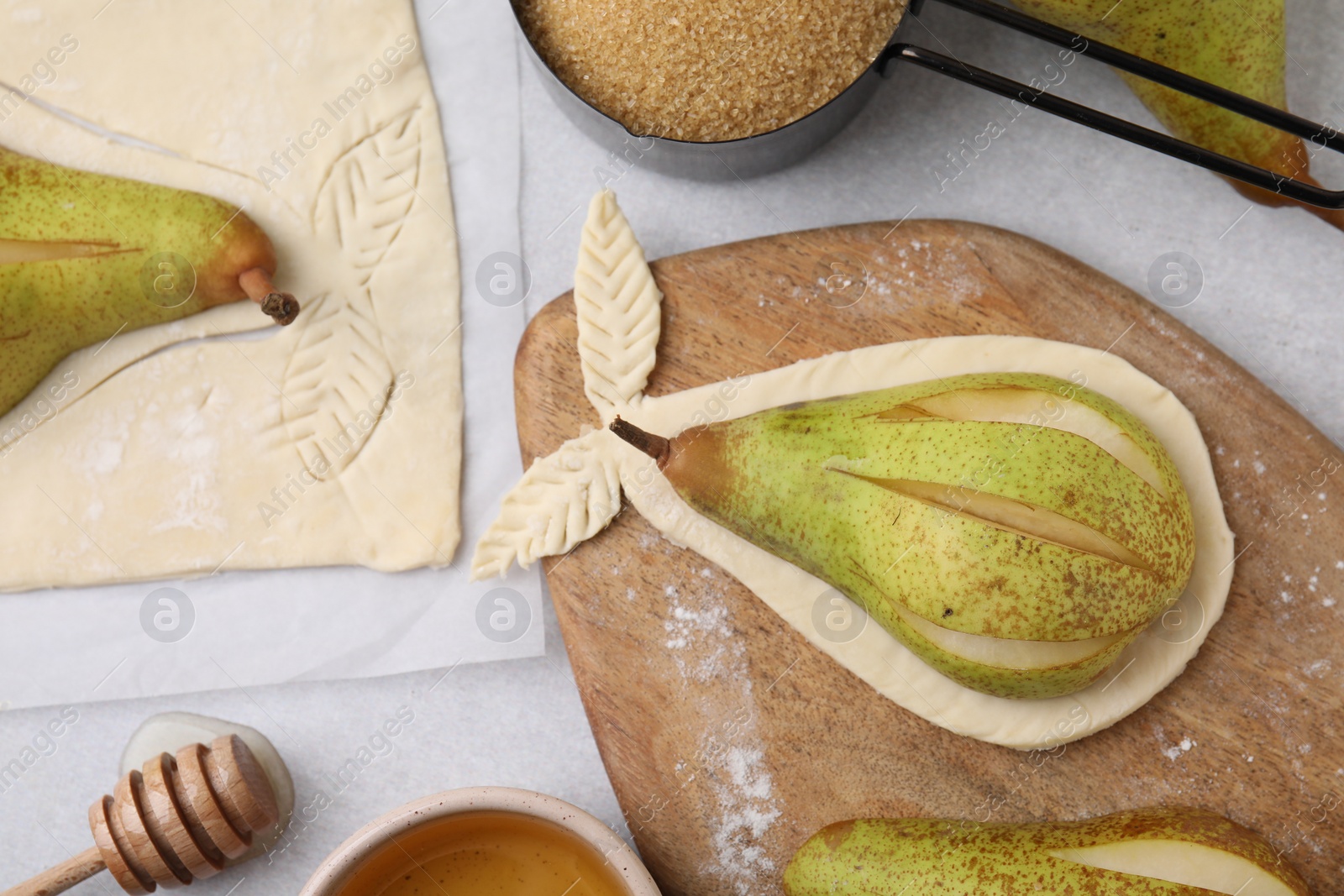 Photo of Raw dough with fresh pears and honey on white table, flat lay