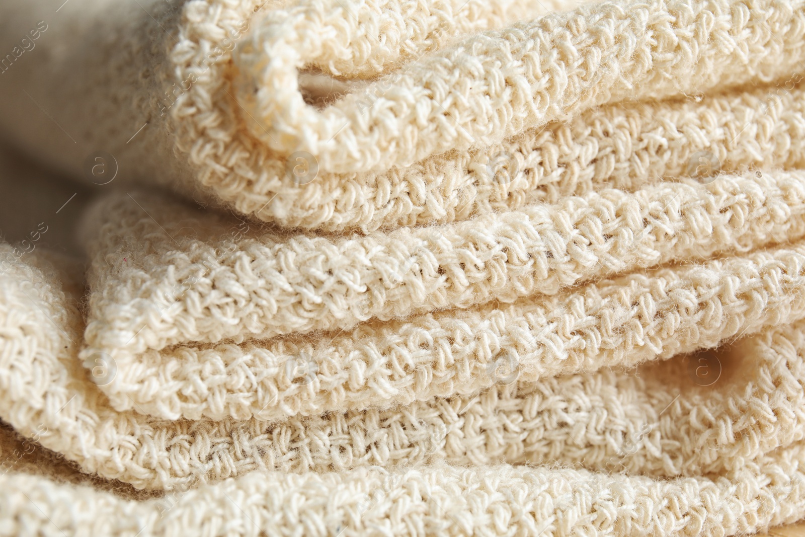 Photo of Closeup view of folded natural hemp cloth. Fabric texture