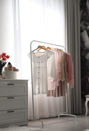 Rack with stylish women's clothes indoors. Interior design