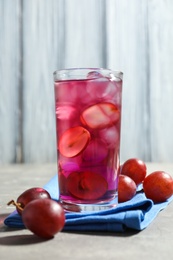 Photo of Delicious grape soda water on grey table. Refreshing drink