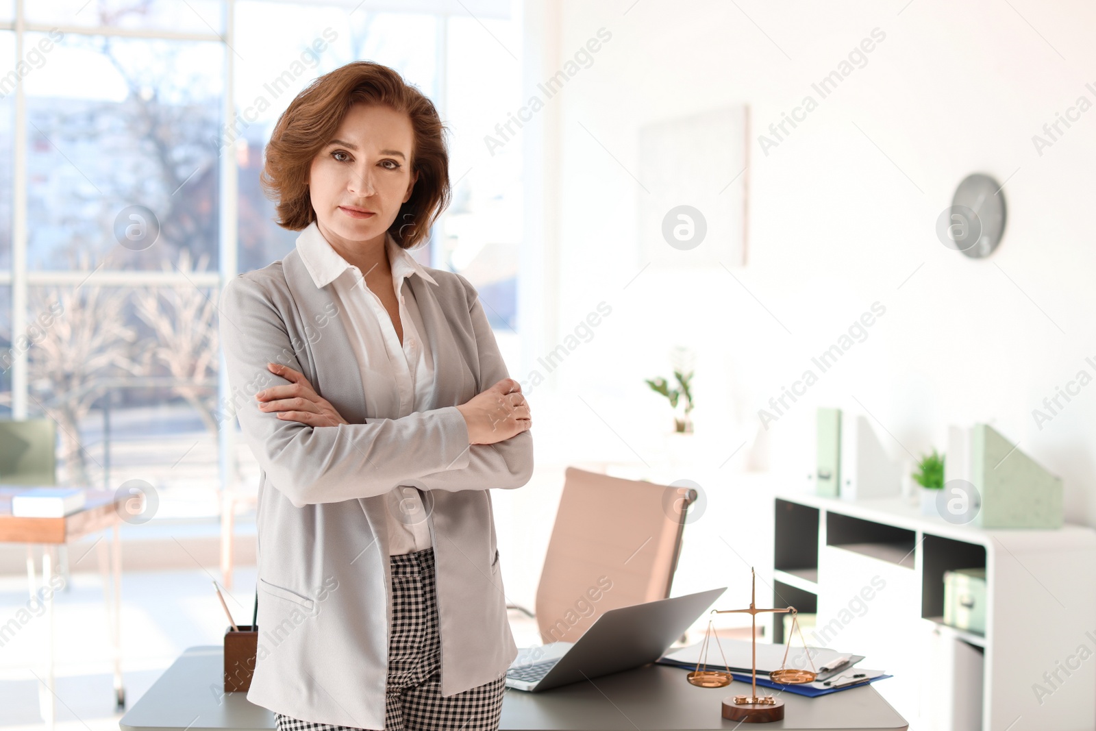 Photo of Female lawyer standing near table in office