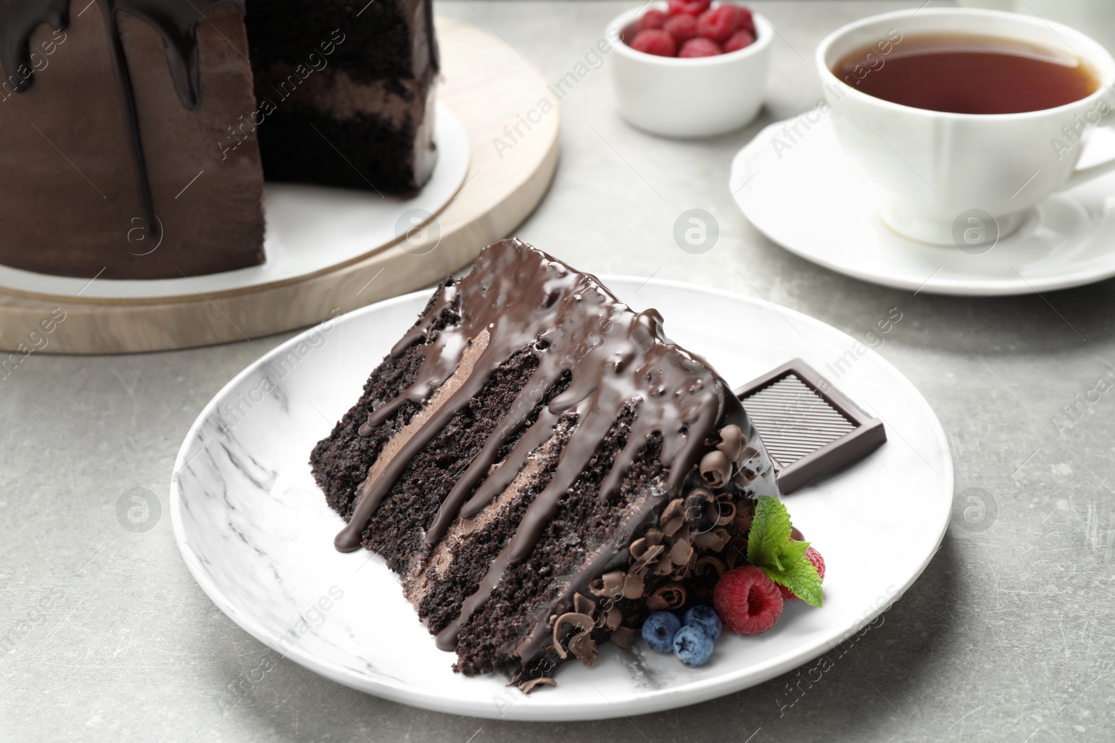 Photo of Piece of delicious chocolate cake decorated with fresh berries served on white table